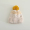 Détail du bonnet en maille bébé avec pompon jaune et motifs de cœurs rouges sur beige - 3-10 ans / Jaune