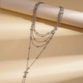 Dettaglio di collana a catena d'argento multistrato con perline e ciondolo a croce di zirconi - Argento