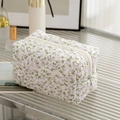 Quilted floral makeup bag with purple flower patterns and a secure white zipper closure - New Purple Floral