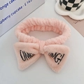 Pink plush headband with OMG embroidery and bow for skincare and makeup routines - Lotus Pink