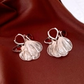 Détail de boucles d'oreilles rose doré avec gemmes rouges sur soie marron - Or Café Clair (Couleur Café)