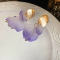 Close-up of purple gradient acrylic petals and golden metallic studs on white ceramic - Purple