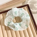 Floral print mesh scrunchie in white with green dots and bow tie on jewelry tray - Green Polka Dot Bow