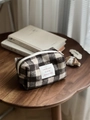 Détail d'une trousse de maquillage en tweed à carreaux avec fermeture éclair et étiquette - Carreaux Café