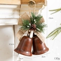 Pair of vintage rusty red iron Christmas bells with burlap bows and pine cone accents - Painted Coffee Open Double Bells