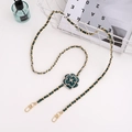 Detail of elegant gold metal chain woven with green leather and pearl camellia charm - Crossbody Chain / Green