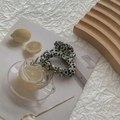 Detail of minimalist cream acetate claw clip with black speckled pattern on a tray - Black Spotted