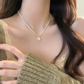 Collier élégant en perles blanches avec pendentif rose dorée sur un mannequin - Perle Rose Nacre Vintage