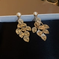 Close-up of golden hollow leaf tassel earrings with white opal stone on black velvet - S925 Silver Needle (HE9935) / Gold