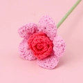 Macro detail of hand-crocheted yarn rose with pink and red petals on a solid pink backdrop - Single-headed Barbie Rose Stem - Gradient Rose Red