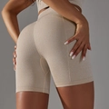 Dettaglio macro del tessuto a nido d'ape senza cuciture sui pantaloncini da yoga - Beige AB