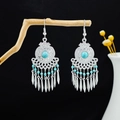 Bohemian silver drop earrings with sky blue beads and tassels hanging on a branch - Blue