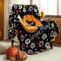Halloween throw blanket with Spooky Season text draped over a white armchair - Black Pumpkin Print / 75*100cm