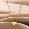 Collier minimaliste avec pendentif cœur doré et chaîne en O sur du satin champagne - Style Coeur