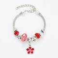 Detailed macro of silver charm bracelet with red floral pendants and crystal beads - Red Floral Bracelet