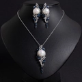 Dettaglio del set collana e orecchini con perle a goccia e gemme blu su busto nero - Blu