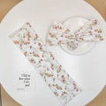 Detail of floral print hair bun maker and matching scrunchie on white display surface - White Floral
