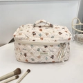 Vue détaillée de la trousse à maquillage matelassée beige avec motifs ours et rubans - Ours Bonne Nuit