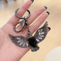 Retro eagle keychain featuring black faceted gem and white cat-eye stone wings - Gunmetal