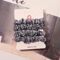 Macro shot of 4-pack grey satin hair scrunchies on a professional display card - Blue Grey