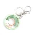 Detailed macro view of handmade tree of life keychain with green stones and copper wire - Green Aventurine