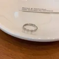 Close-up of a silver heart ring with micro-paved zircons on a white ceramic tray - Heart Ring (Single)