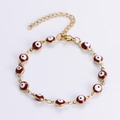 Detailansicht der goldenen Evil Eye Armband mit burgunderfarbenen Emaille-Perlen - Rot