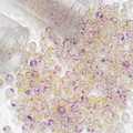 Macro detail of purple and yellow spotted glass beads pouring from clear tubes - 10mm Spotted Beads / Purple Gold