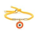 Yellow woven Evil Eye bracelet with gold beads and orange enamel charm on white background - Yellow