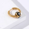 Gedetailleerde close-up van gouden roestvrijstalen oorring met zwart-wit evil eye bedel - Goud-Zwart