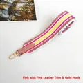 Detailed view of the colorful pink striped woven wide shoulder strap with gold metal hooks - Pink with Pink Trim