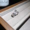 Macro shot of silver crossover ring encrusted with zircon stones on gray velvet box - Style 9 Cross Shape Pave Design (Silver Single Piece)
