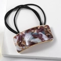 Detail of square acetate hair tie with purple marble pattern and gold metal frame - Purple
