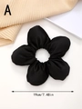Detail view of black 19cm floral satin hair scrunchie with 3D petal texture - Black