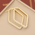 Macro view of gold plated stainless steel diamond earrings on beige leather box - Diamond