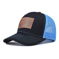 Dettaglio della toppa in pelle con bandiera USA e rete blu traspirante sul cappello trucker - Nero e Blu Reale