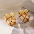 Primer plano de pendientes geométricos bañados en oro con cubos 3D y marcos cuadrados - Dorado
