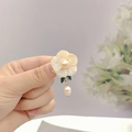 Dettaglio ravvicinato di orecchini a fiore con perla e foglia smaltata verde - Bianco Fiore