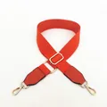 Detail eines verstellbaren orangefarbenen Canvas-Gurts mit goldenen Metallhaken und PU-Leder - Orange