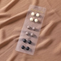 Macro detail of 12-piece magnetic silk scarf buckle set in matte beige, tan, and black - Mixed (SET-5)