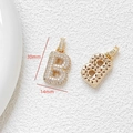 Macro detail of gold letter B pendant with cubic zirconia inlay 30mm x 14mm size - Letter B