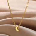 Vue macro du pendentif croissant de lune doré sur un fond élégant en soie champagne - Style Lune