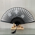 Elegant black and white floral silk folding fan with bamboo ribs and tassel on wood stand - Ephemeral Bloom