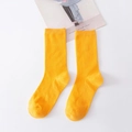 Solid yellow mid-calf cotton socks with vertical ribbed texture on white surface - Gold