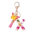Macro view of resin letter X keychain with pink floral filling and a silk tassel - Flower Pattern X
