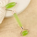 Dual-headed light green jade face roller with rose gold metal frame on a white display - Resin Double Head Roller Transparent Green