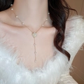 Golden Y-shaped pearl necklace featuring a diamond-encrusted rose pendant on a model - Zircon Flower Pearl Tassel Necklace