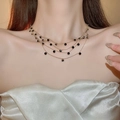 Detail of layered gold necklace featuring black round gemstones on a female model - Gold Layered Black Round Necklace