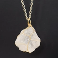 Macro detail of natural white crystal pendant with handmade gold wire wrapping - Gold + Clear Quartz