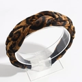 Close-up of a braided leopard print headband on a clear display with white background - Dark Brown Leopard